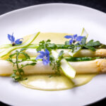 green and white asparagus topped with edible nasturtium flowers
