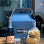 mothers day gift box assortment on counter top with champagne, caviar, chips, creme fraiche and chives
