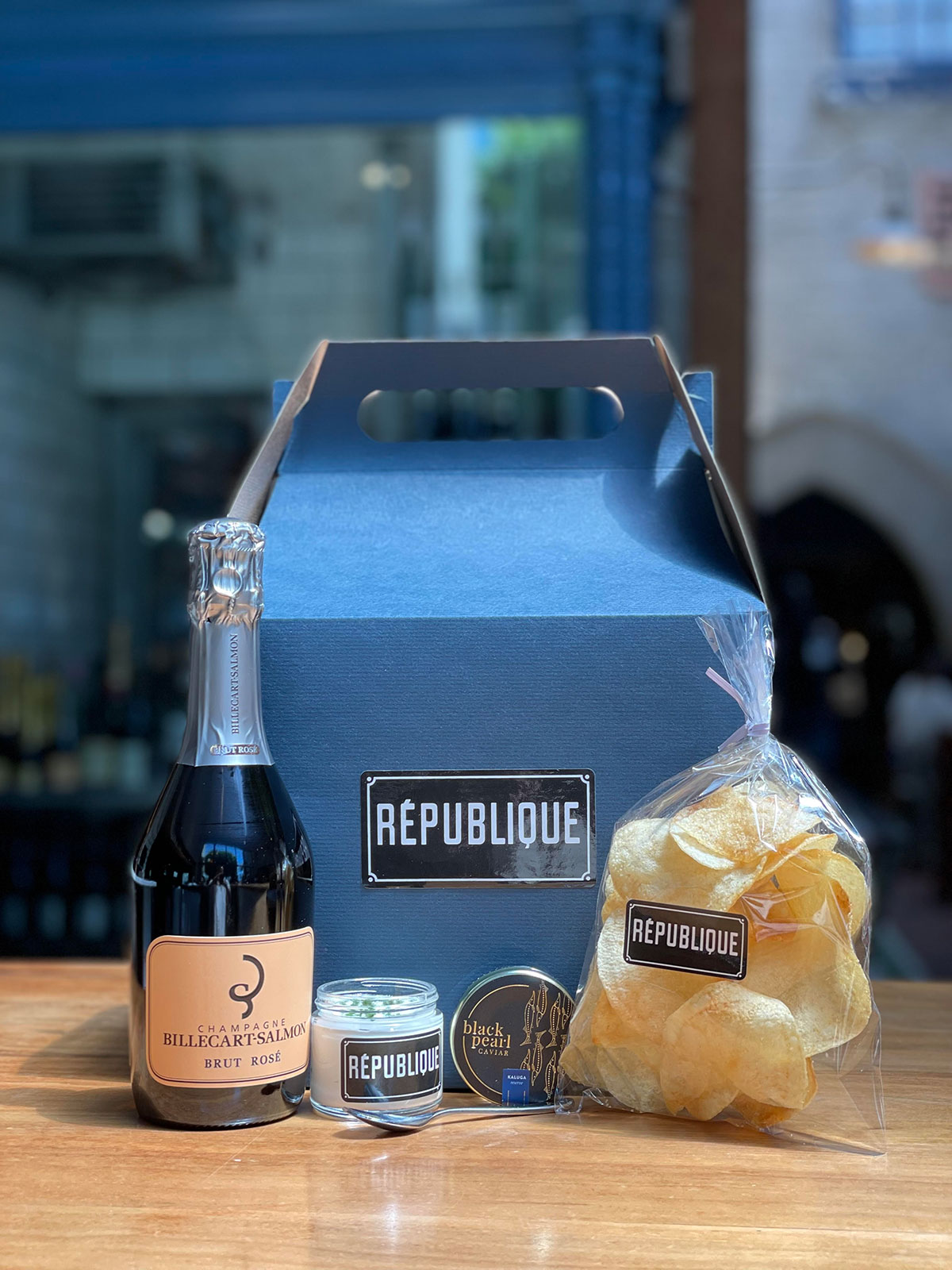 mothers day gift box assortment on counter top with champagne, caviar, chips, creme fraiche and chives