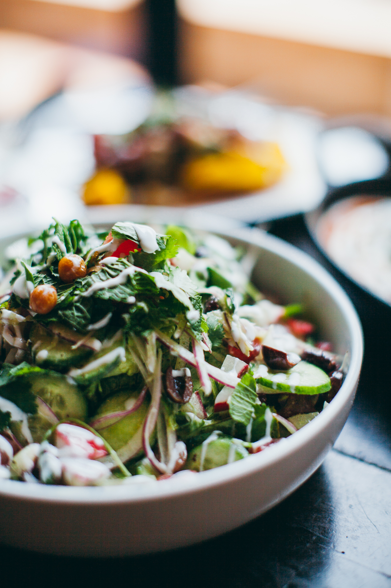 bow of republique's grilled chicken salad in focus as part of a breakfast tablescape