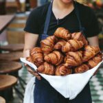 chef margarita manzke holding a tray of croissants at republique